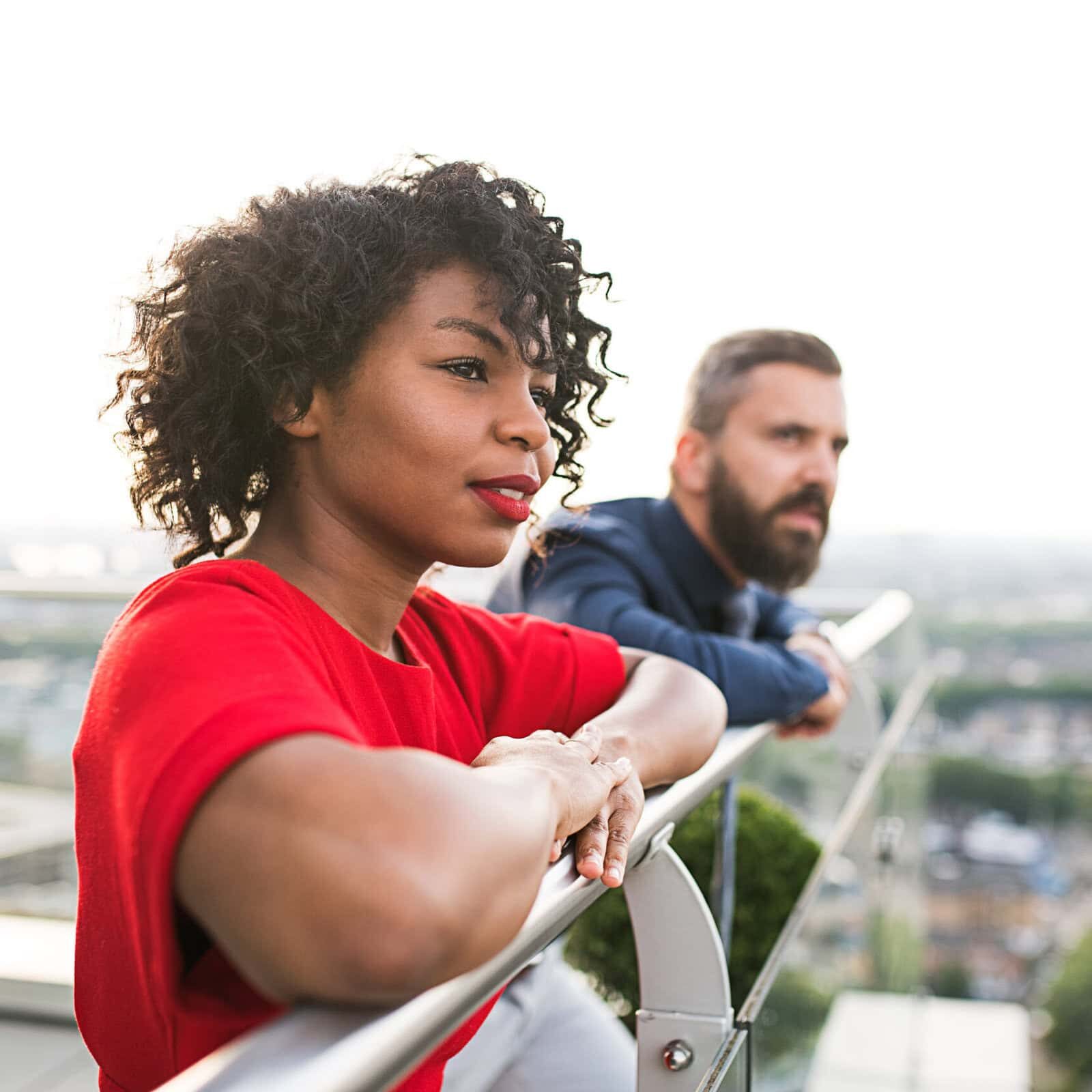 A portrait of two businesspeople standing against London view panorama. Future coach exploring how to turn passion for helping others into a career.