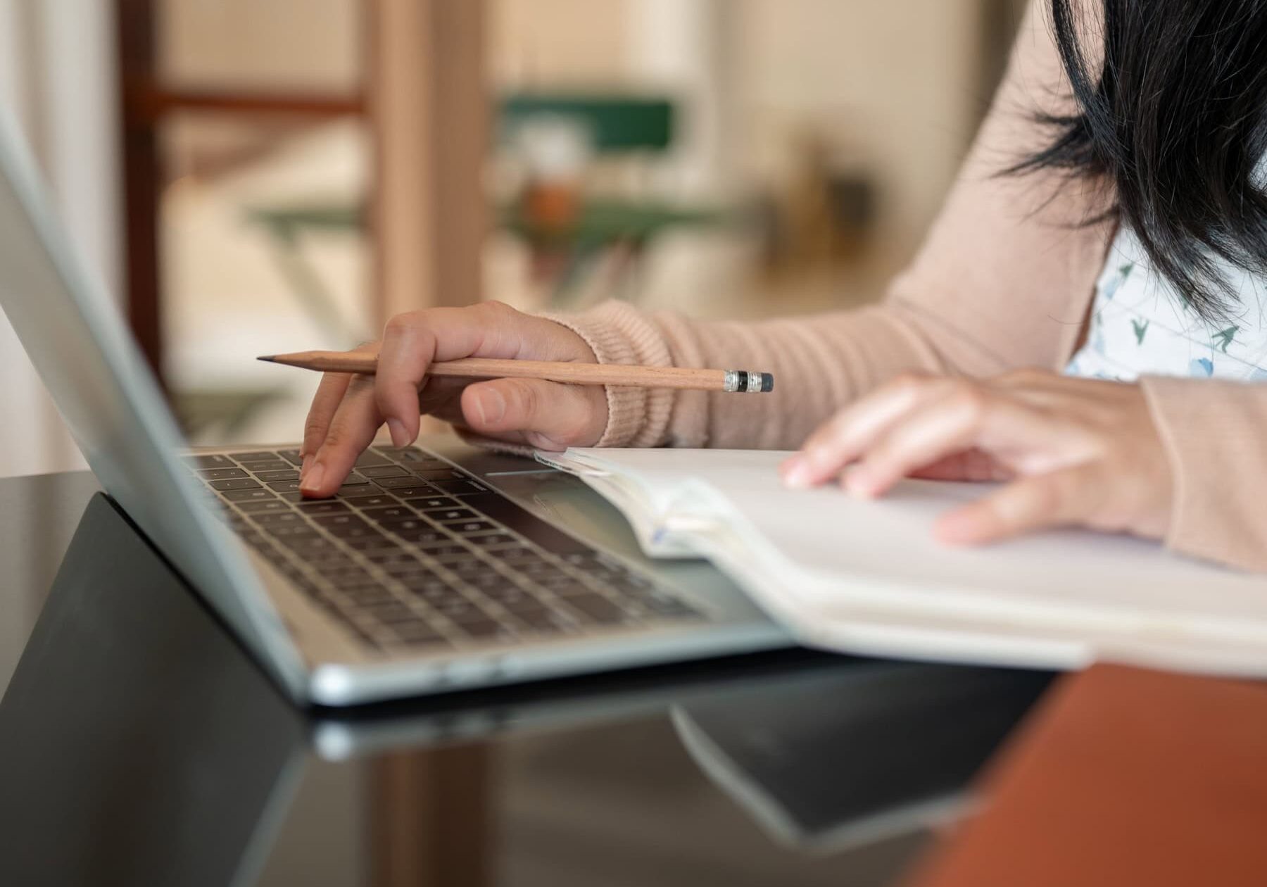 icf-digital-research-portal A woman is using a laptop and taking notes form the research portal