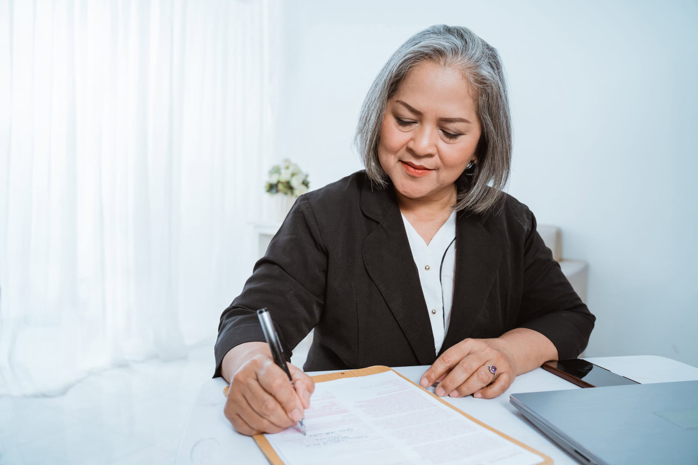 Old woman beautiful mature asian woman doing business A woman is documenting her mentor coaching experience for her credential application